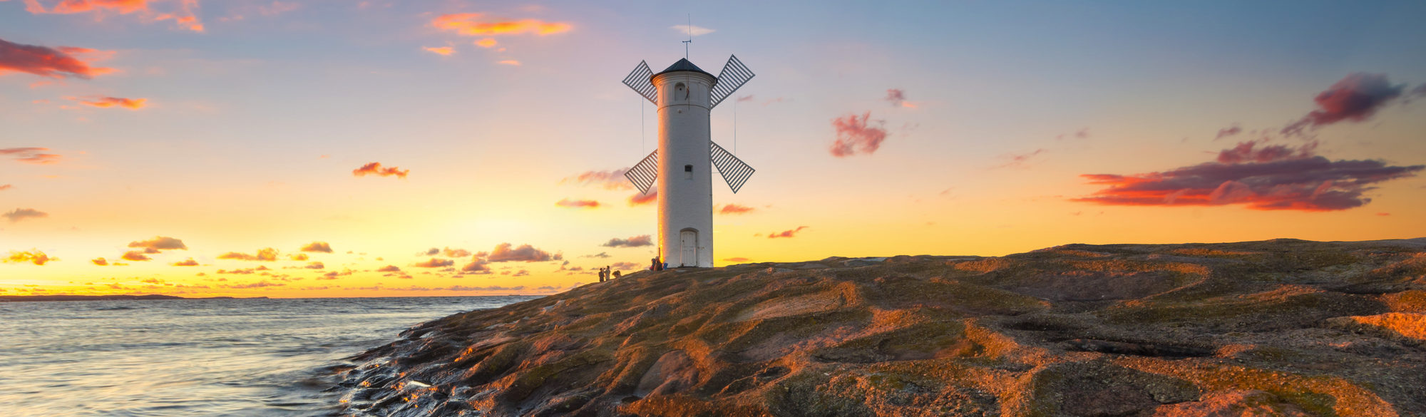 Beautiful sunset over a windmill-shaped lighthouse, Swinoujscie, Poland