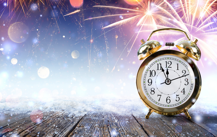 Mitternachts Celebration - Uhr auf verschneiten Tisch mit Feuerwerk