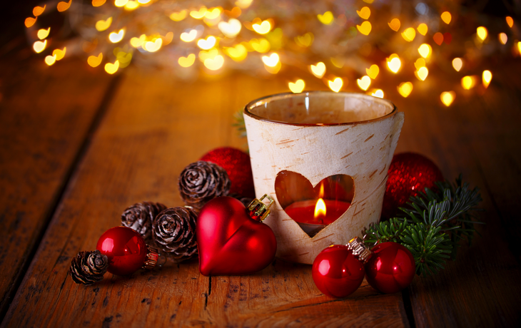Christmas background --  Decoration with burning candle and  heart shaped lights on wood