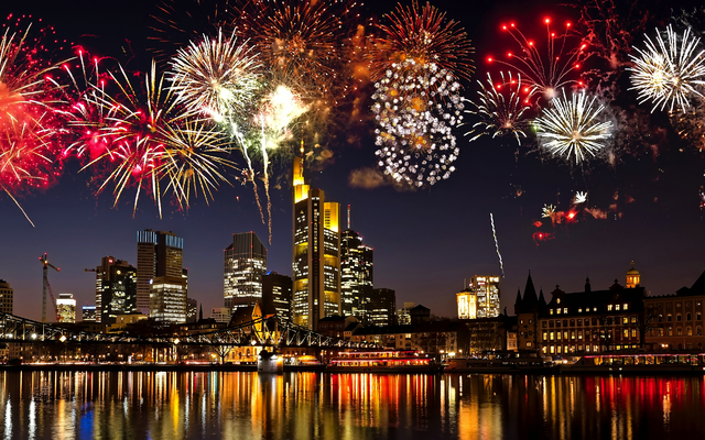 Feuerwerk über einer beleuchteten Großstadt-Skyline bei Nacht.