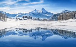 Verschneite Berglandschaft mit Spiegelung im ruhigen See.
