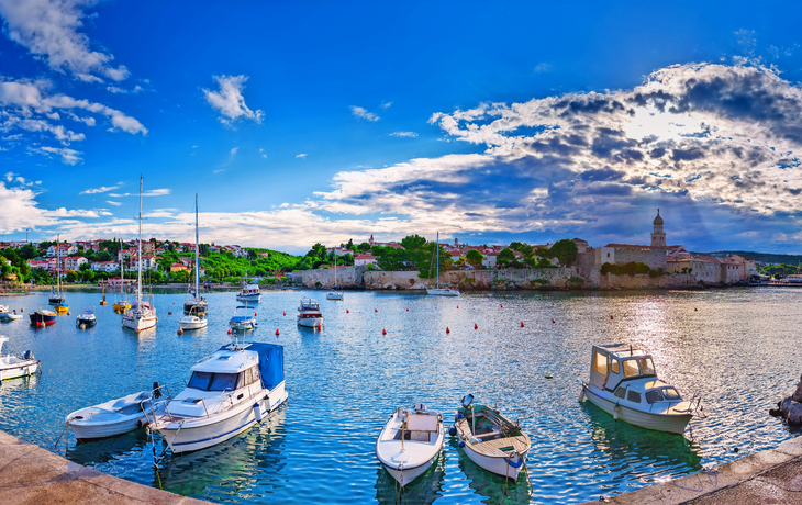 Wunderbares romantisches Sommerabendlandschaftspanorama-Küstenlinie adriatisches Meer. Boote und Yachten im Hafen am azurblauen Wasser cristal. Altstadt von Krk auf der Insel Krk. Kroatien. Europa.