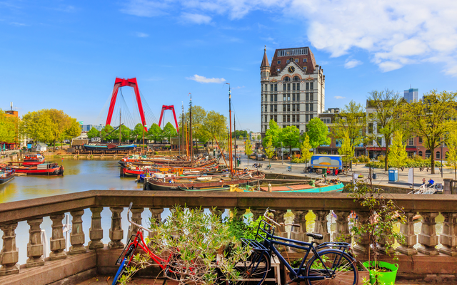 Fahrrad auf einer Brücke mit Blick auf einen Hafen und historische Gebäude.