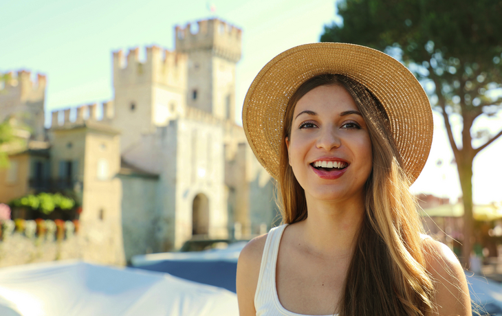 Porträt einer lächelnden Touristenin mit Schloss Sirmione