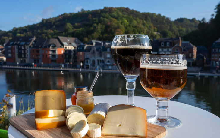 Glas belgisches Abteibier und Verkostung von Käse aus Trappistenbier und feinen Kräutern mit Blick auf die Maas in Dinant