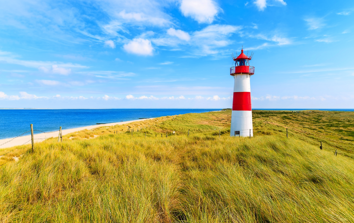Ellenbogen Leuchtturm auf Sanddüne gegen blauen Himmel mit weißen Wolken an der Nordküste der Insel Sylt, Deutschland