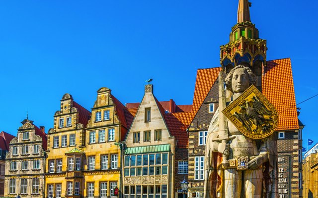 Rathausplatz in Bremen mit der Statue des Roland und bunten Fassaden im Hintergrund.