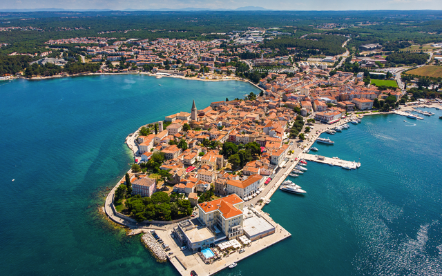Luftaufnahme einer Küstenstadt mit blauen Wasser und historischen Gebäuden.