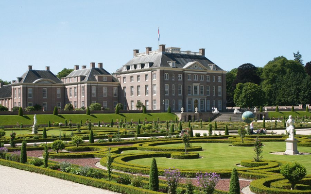 Palais Het Loo mit gepflegten Gärten und symmetrischen Beeten im Vordergrund.