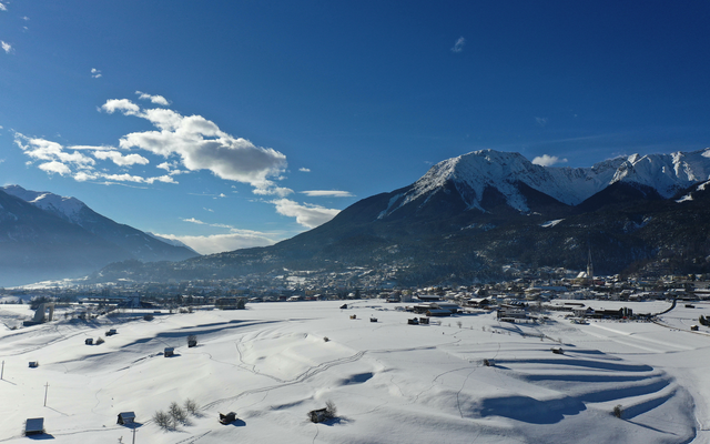 Verschneite Landschaft mit Bergen und blauen Himmel.