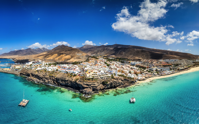 Panoramabild einer Küstenstadt mit blauem Meer und hellem Sonnenschein.