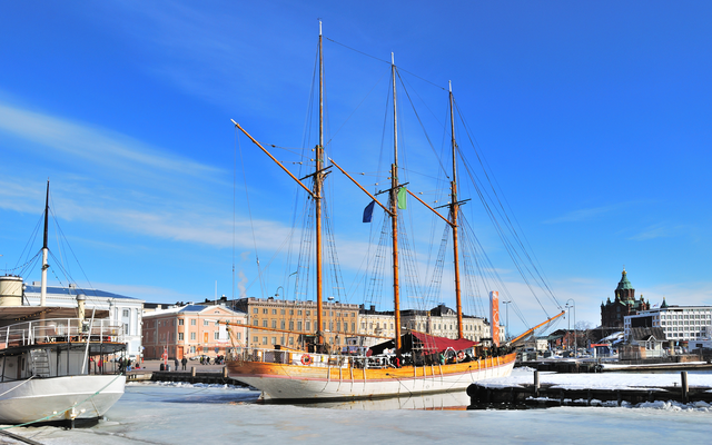 Segelschiff im Hafen bei eisigem Wetter, blaue Himmel im Hintergrund.