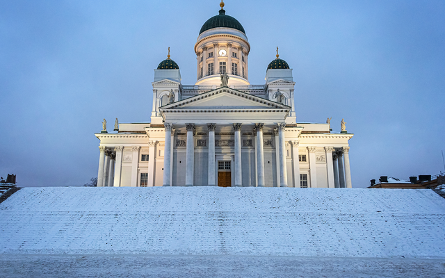 Panoramafoto der Kathedrale von Helsinki im Winter mit schneebedecktem Boden und klarem Himmel.