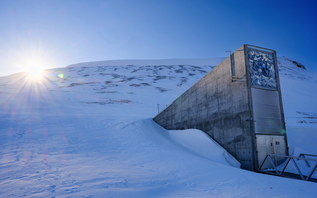 Eingang zu einem unterirdischen Bunker in schneebedeckter Landschaft bei Sonnenschein