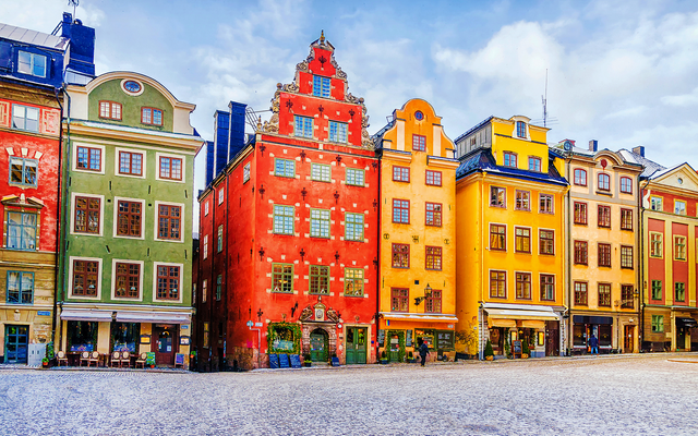 Stockholm im Winter mit bunten Altbauten, verschneiter Platz, weihnachtliche Atmosphäre.