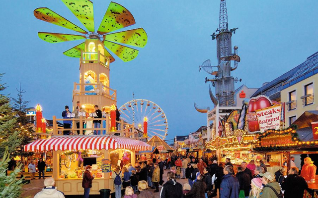 Weihnachtsmarkt mit Ständen, Lichtern und einem großen Windrad in Aurich.