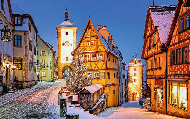 Verschneite Altstadt von Rothenburg ob der Tauber bei Dämmerung.
