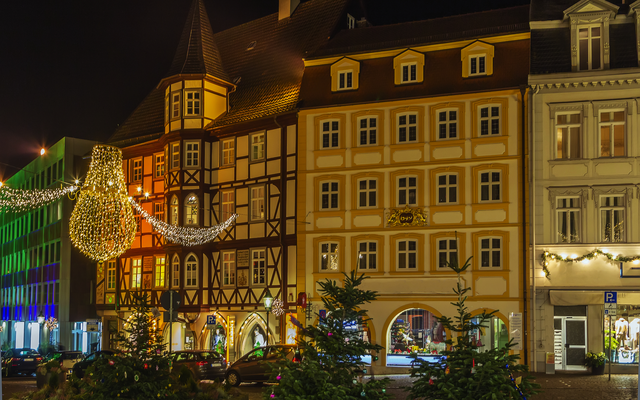 Beleuchtete Fachwerkhäuser bei Nacht mit Weihnachtsdekorationen.