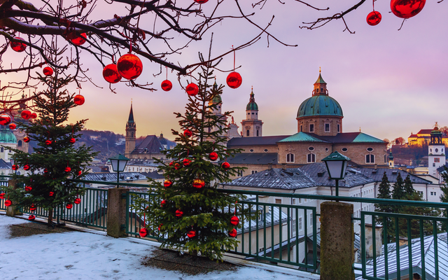 Winterlandschaft mit Weihnachtsbäumen und Kirche im Hintergrund.