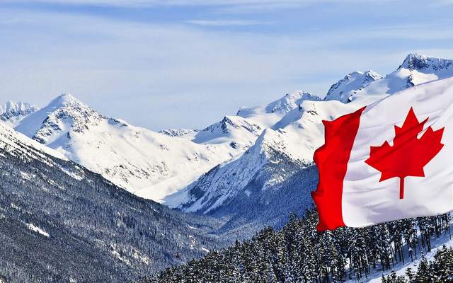 Kanadische Flagge weht vor schneebedeckten Berggipfeln.