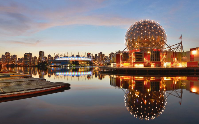 Blick auf die Vancouver Skyline mit reflektierenden Gebäuden bei Sonnenuntergang.