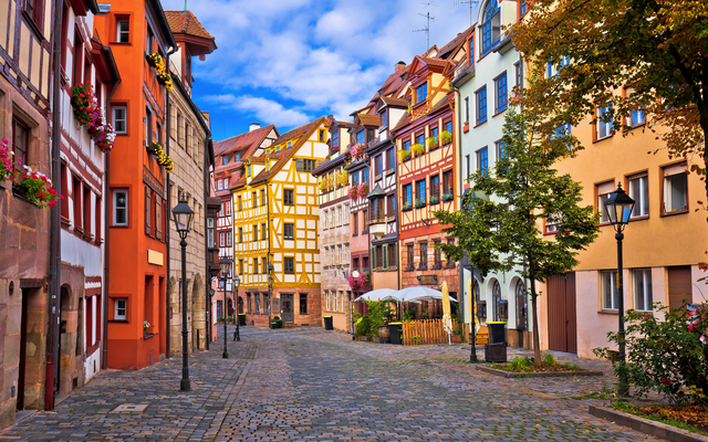 Eine malerische Altstadtgasse mit bunten Fachwerkhäusern.