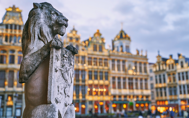 Löwenstatue auf einem Platz mit historischen Gebäuden im Hintergrund