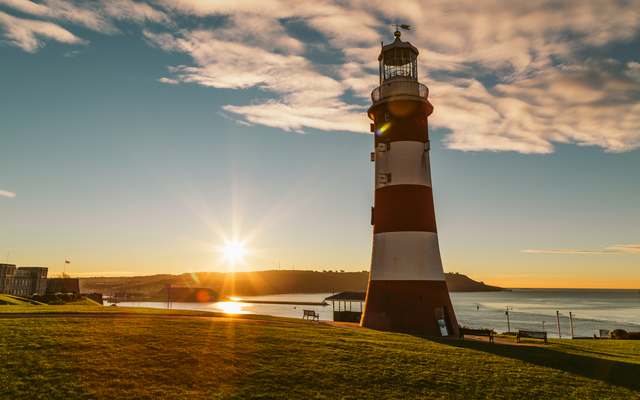 Leuchtturm bei Sonnenuntergang mit Meer und Himmel im Hintergrund