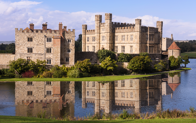 Historisches Schloss mit Wassergraben und Spiegelung im Wasser.