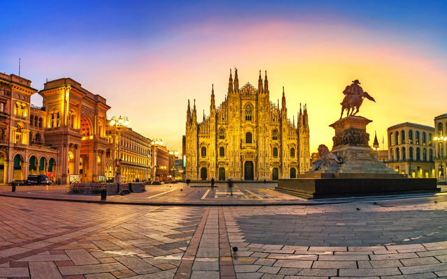 Milans Domplatz bei Sonnenuntergang mit prächtigem Gebäude und Reiterdenkmal.