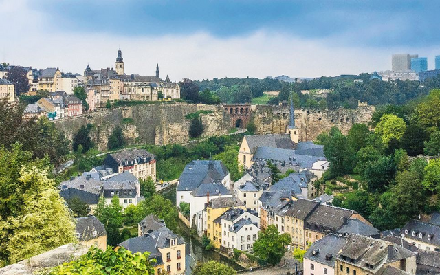 Stadtpanorama mit historischen Gebäuden und grünen Bäumen.