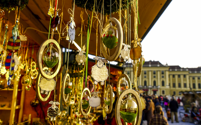 Weihnachtsdekorationen an einem Marktstand mit Gebäuden im Hintergrund.
