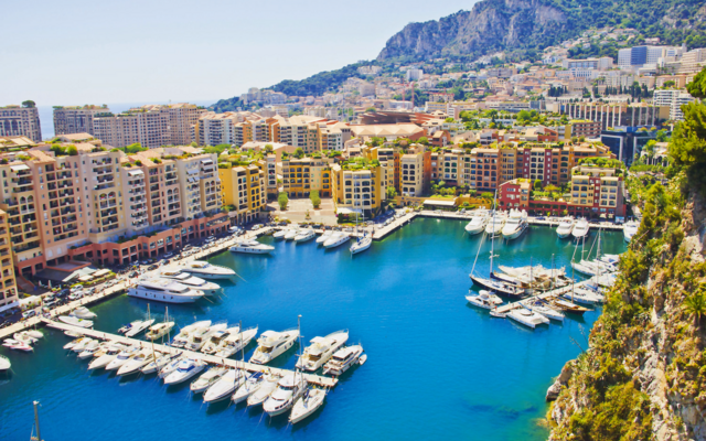 Blick auf den Hafen von Monte Carlo in Monaco mit Yachten und umliegender Architektur.