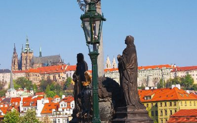 Statue auf der Karlsbrücke in Prag mit Blick auf die Altstadt und die Prager Burg.