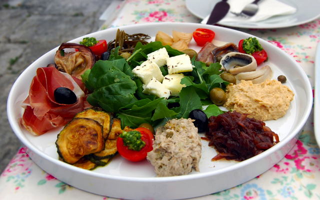 Teller mit gemischten Antipasti, darunter Käse, Oliven und Salat.