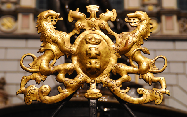 Goldenes Wappen von Danzig am Neptunbrunnen in Gdansk, Polen, mit einem Löwen und einer Krone.
