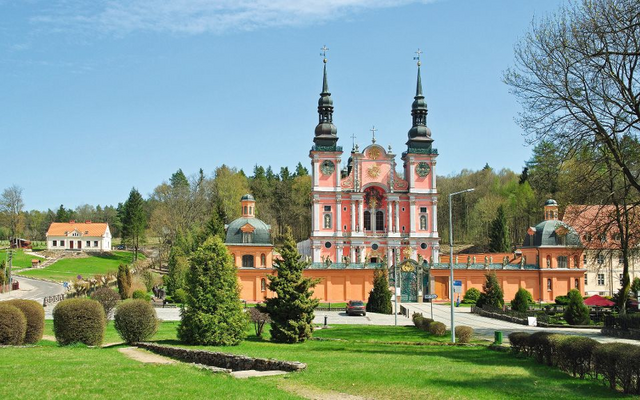 Barockkirche in Landschaft mit blauen Türmen und gepflegtem Garten.