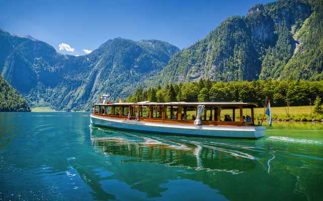 Boot auf einem malerischen See umgeben von Bergen und Wäldern
