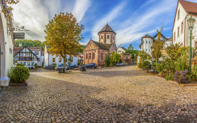 Historischer Marktplatz mit Kirche und Fachwerkhäusern an einem sonnigen Tag.