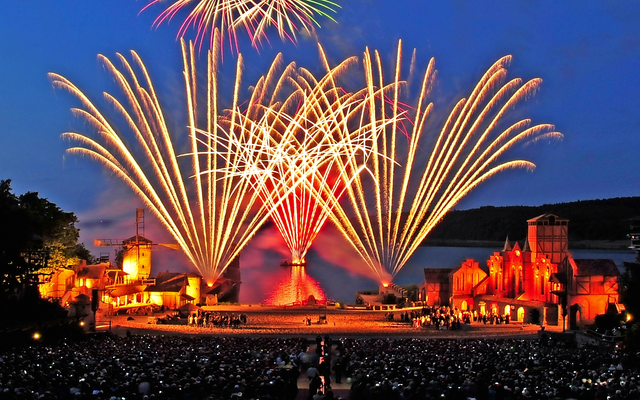 Feuerwerk über beleuchteter Bühne bei den Störtebeker Festspielen.