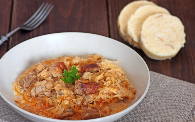 Eine Schüssel Szegediner Gulasch mit Sauerkraut und Brotknödeln.