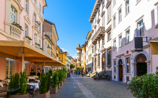 Malerische italienische Straßenszene mit historischen Gebäuden und Straßencafé.