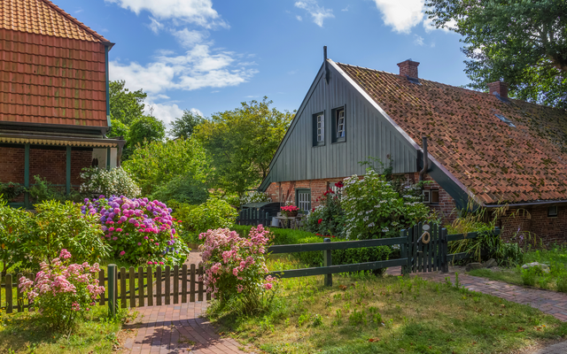 Traditionelles Haus mit Garten und Blumen im Sommer.