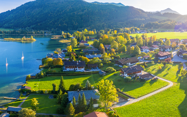 Malerische Seelandschaft mit Segelbooten und Bergen im Hintergrund bei Sonnenschein