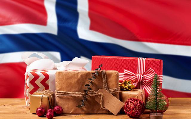 Weihnachtsgeschenke vor wehender norwegischer Nationalflagge im Winter.