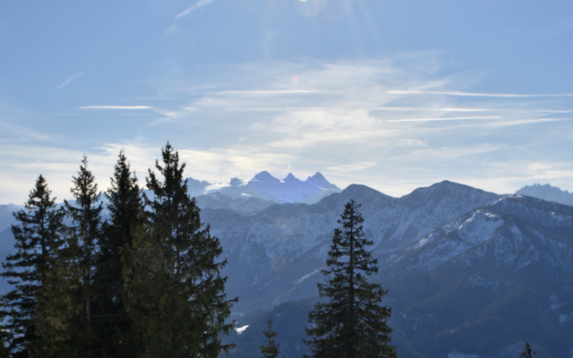 Teller mit Kaiserschmarrn vor Berglandschaft und Sonnenschein