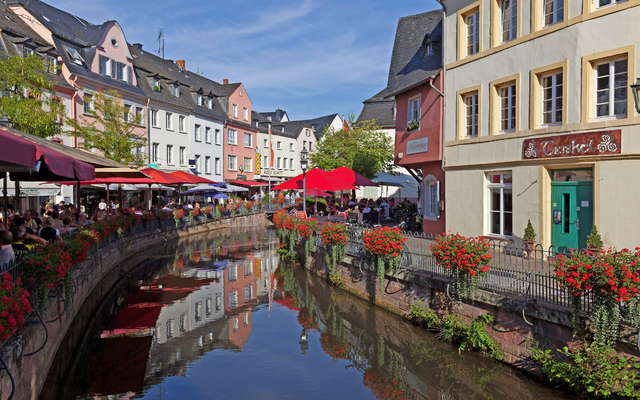 Malebach mit Blumen und farbenfrohen Gebäuden im Sonnenschein