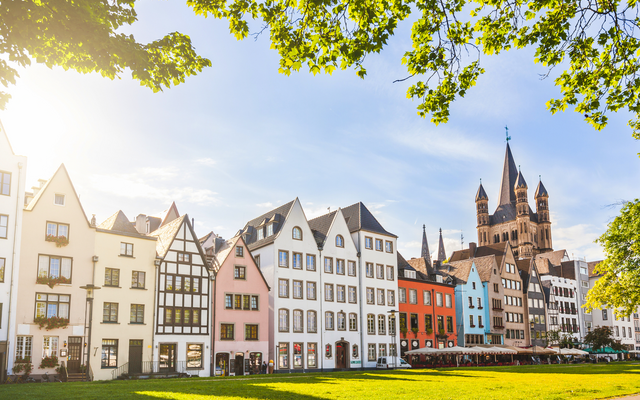 Bunte Fachwerkhäuser und Kirche an einem sonnigen Tag.