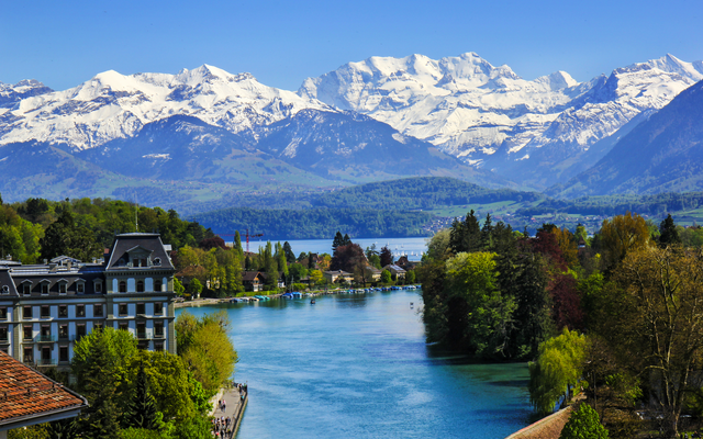 Flusslandschaft mit Bergen im Hintergrund unter blauem Himmel