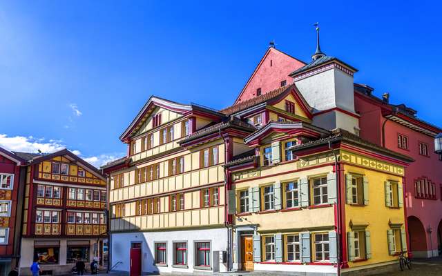 Historische Gebäude mit bunten Fassaden unter blauem Himmel.